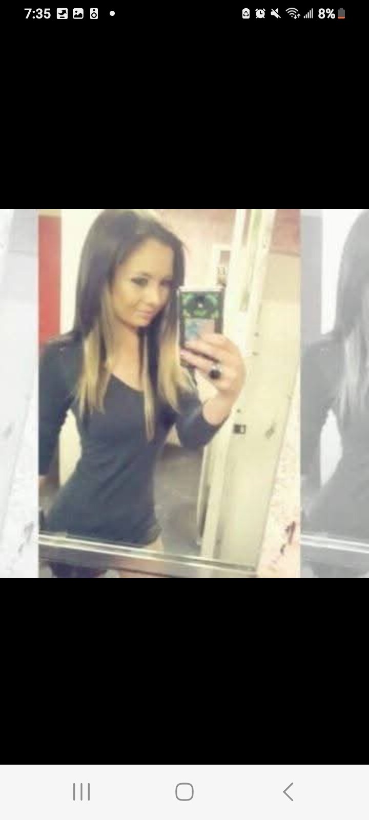 Jennifer Jorgensen Ahmed in a black long-sleeve top with blonde-streaked hair taking a mirror selfie