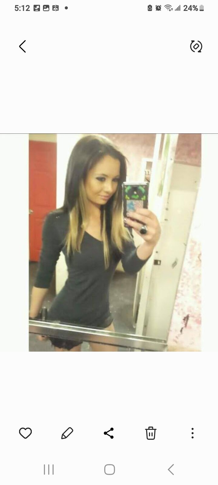 Jennifer Jorgensen Ahmed in a black dress with two-tone hair taking a mirror selfie