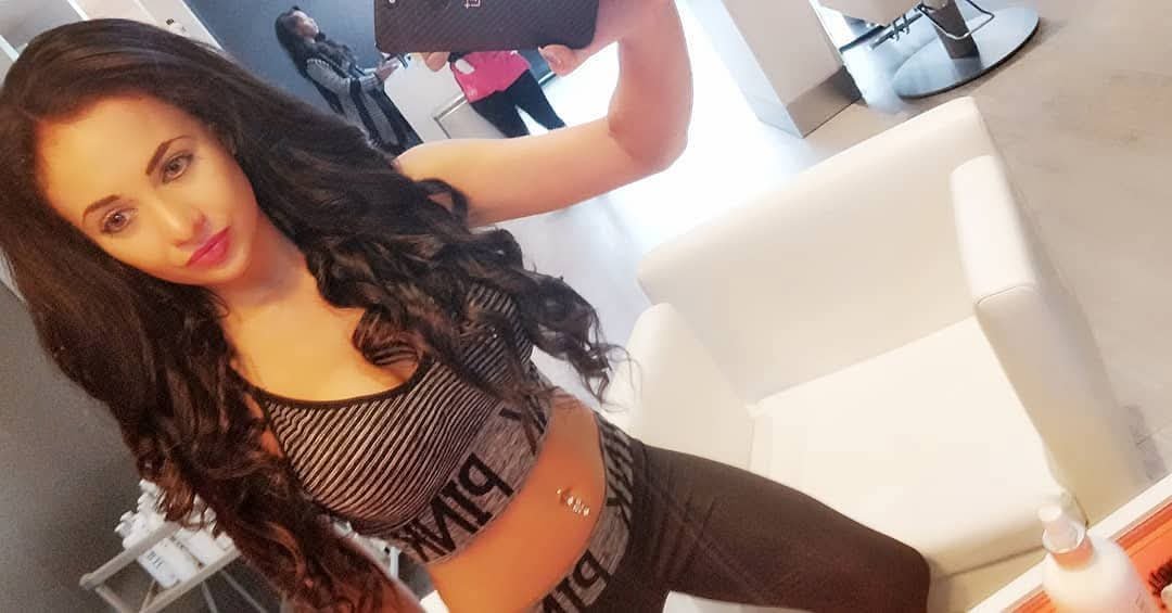 Jennifer Jorgensen Ahmed with long dark wavy hair in a striped top taking a selfie