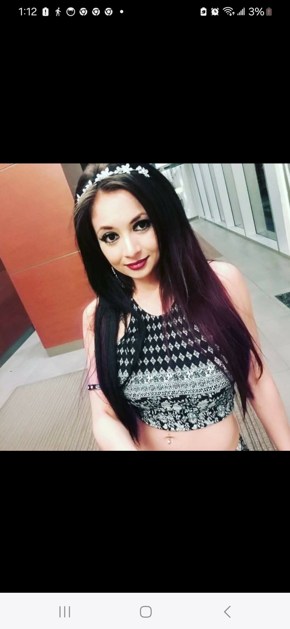 Jennifer Jorgensen Ahmed with long dark hair and a floral headband in a patterned crop top
